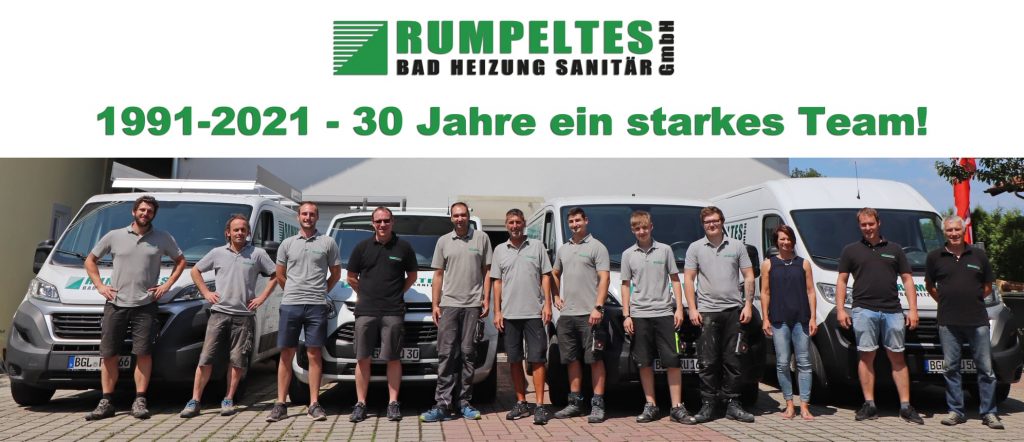 30 Jahre - ein starkes Team - Mitarbeiter der Firma Rumpeltes Bad Heizung vor Firmenfahrzeugen auf dem Betriebsgelände in Ainring, Am Sonnwiesgraben 23/25